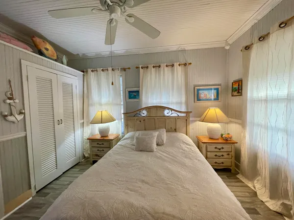 a bedroom with a bed mirror and window