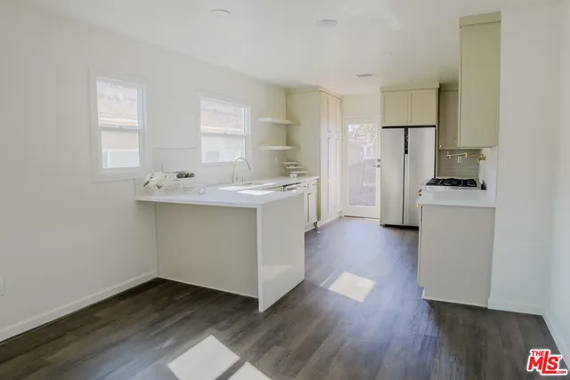 a kitchen with wooden floors and white appliances