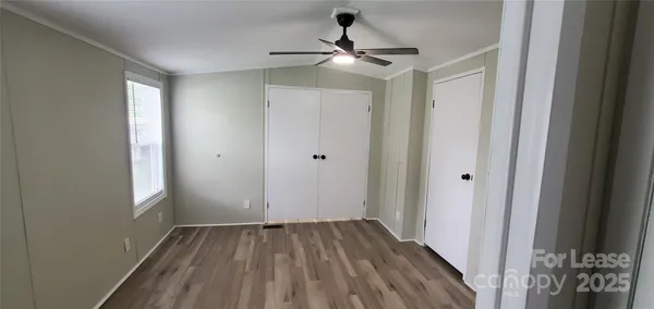 a view of an empty room with wooden floor