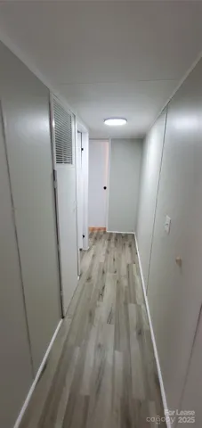 an empty room with wooden floor and entrance