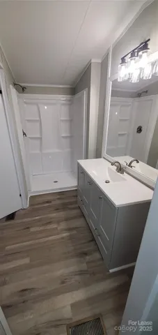 a bathroom with a sink mirror and shower