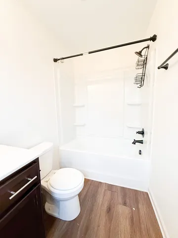 a white toilet sitting next to a shower