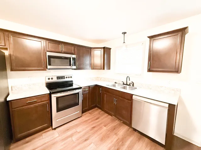 a kitchen with stainless steel appliances granite countertop a stove a sink and a microwave
