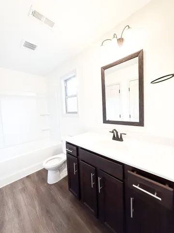 a bathroom with a sink a toilet and mirror
