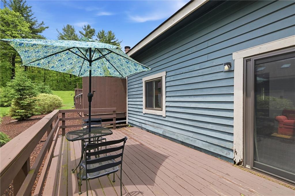 580 Maple Court Hidden Valley, PA 15502 - Photo 22 of 28 a view of a patio with a table and chairs under an umbrella with wooden floor and fence