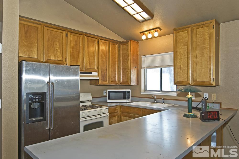 166 Pleasant Valley Road Markleeville, CA 96120 - Photo 8 of 24 a kitchen with stainless steel appliances granite countertop a sink a refrigerator and cabinets