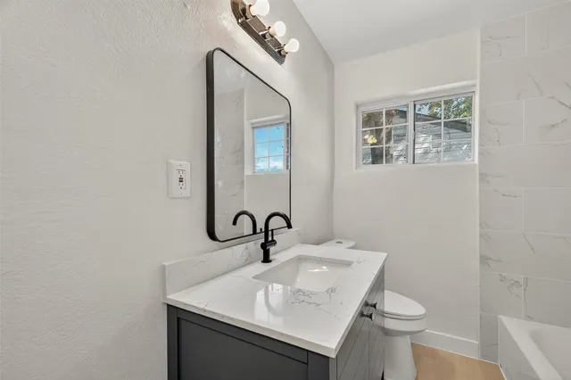 a bathroom with a sink a toilet and mirror