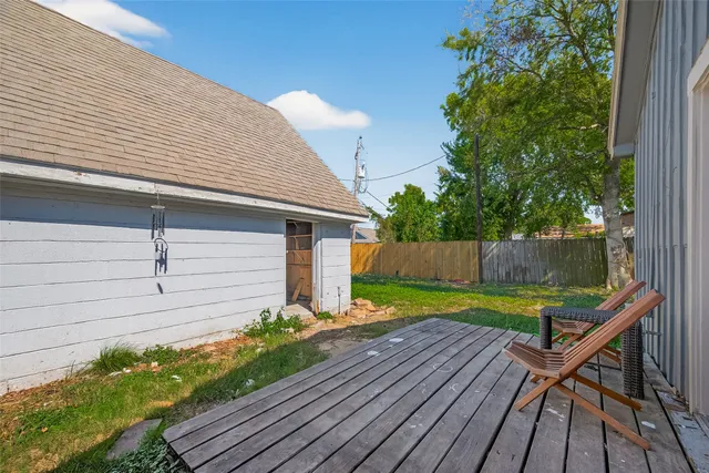 a view of backyard with wooden deck and seating space