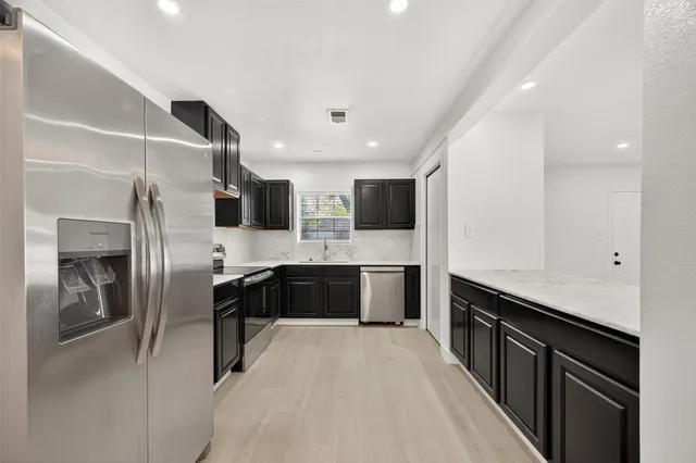 a large kitchen with a large counter top appliances and cabinets