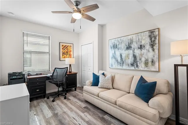 a living room with furniture two window and a flat screen tv
