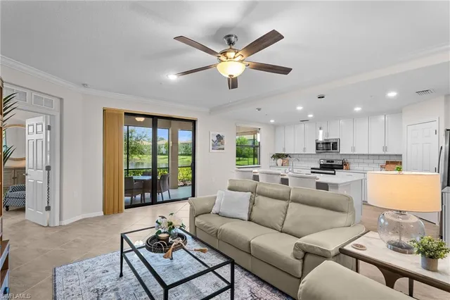 a living room with furniture with a ceiling fan and a large window