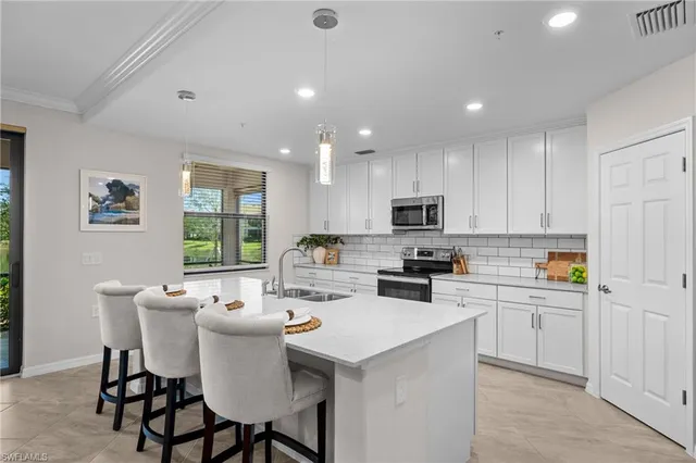 a kitchen with a dining table chairs and refrigerator
