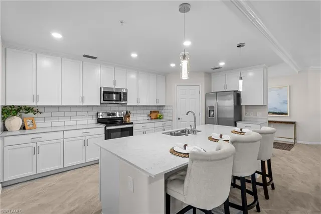 a kitchen with a dining table cabinets appliances and wooden floor