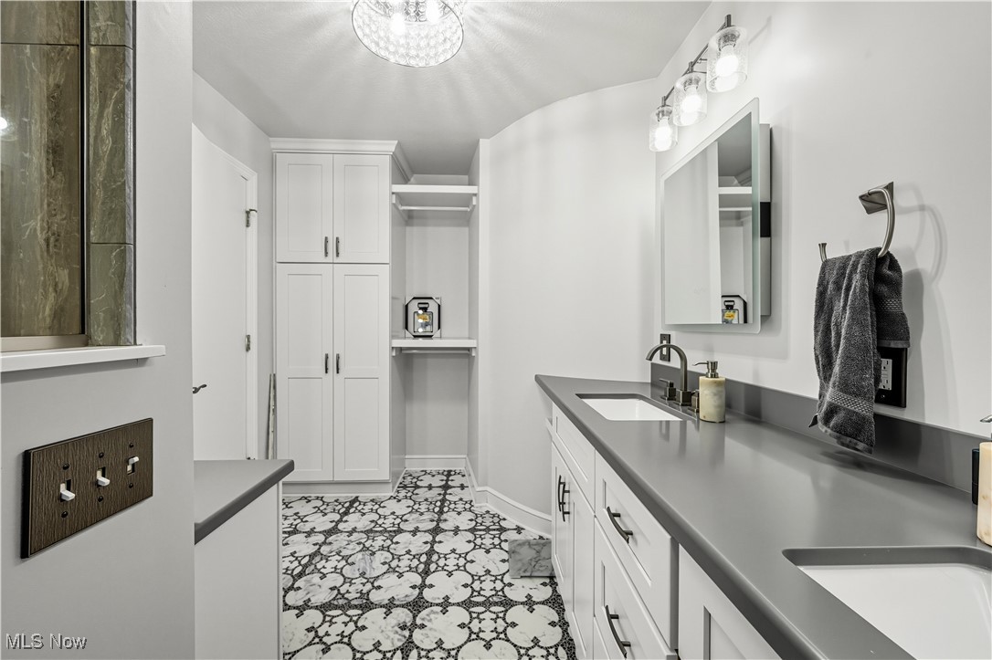 8193 Hartman Road Wadsworth, OH 44281 - Photo 28 of 50 Full bath with a closet, double vanity, light tile patterned floors, and a chandelier