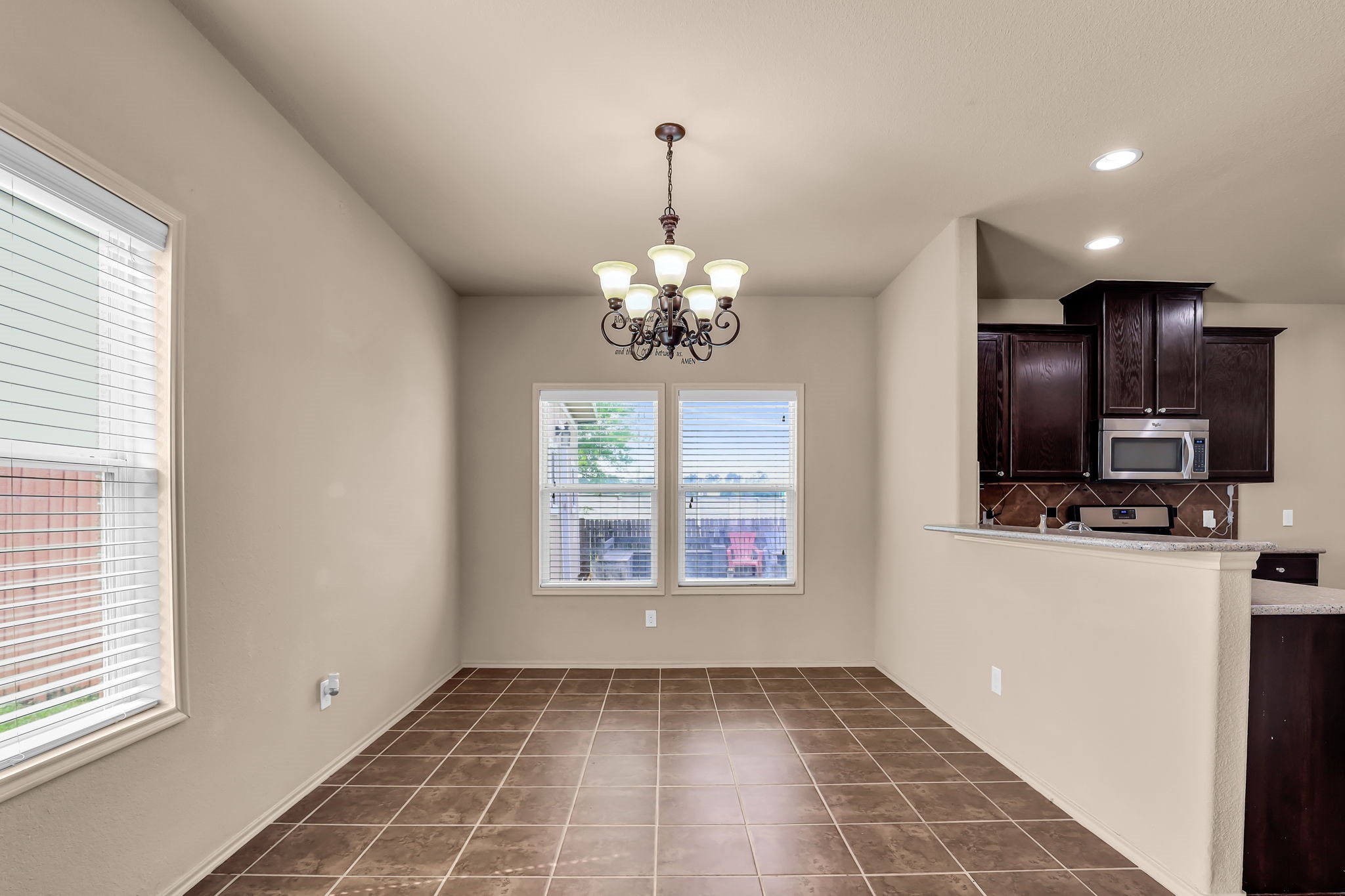 21307 Carleen Creek Trail Spring, TX 77379 - Photo 5 of 25 Cozy breakfast area with tile flooring and a stylish chandelier. It features a window allowing natural light and an open view into a modern kitchen.