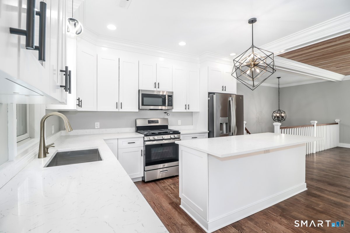 53 Pembroke Road Danbury, CT 06811 - Photo 15 of 37 a kitchen with stainless steel appliances a stove a sink dishwasher a refrigerator white cabinets and wooden floor