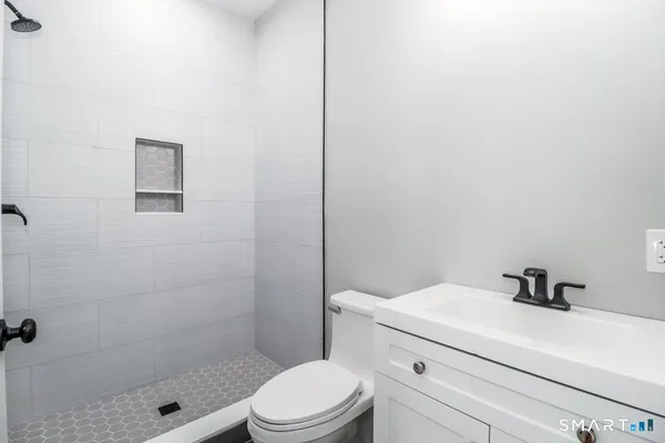 a bathroom with a sink a toilet and shower