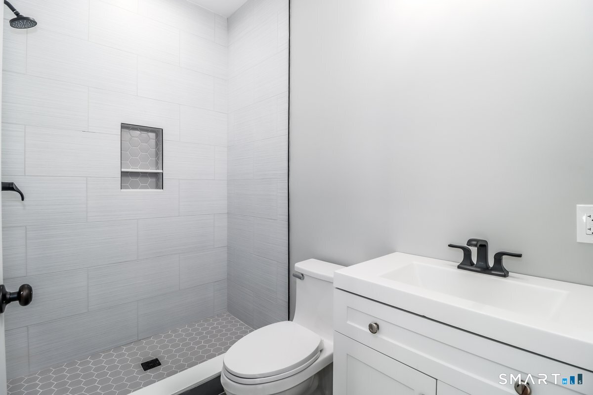 53 Pembroke Road Danbury, CT 06811 - Photo 19 of 37 a bathroom with a sink a toilet and shower