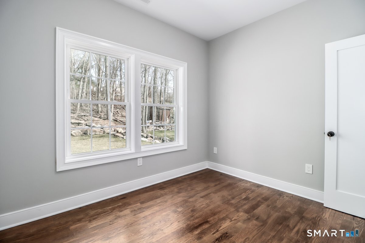 53 Pembroke Road Danbury, CT 06811 - Photo 21 of 37 a view of an empty room with wooden floor and a window