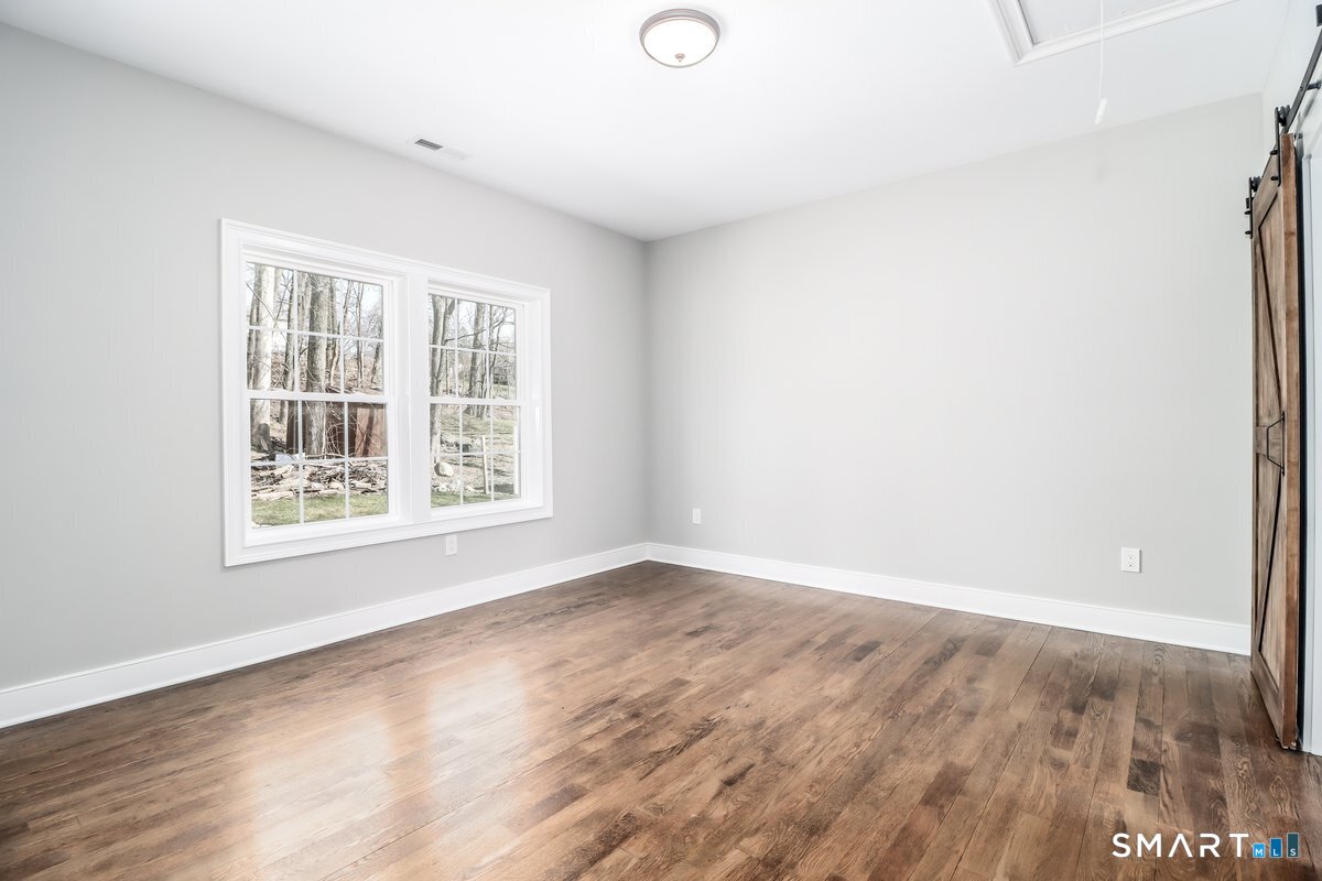 53 Pembroke Road Danbury, CT 06811 - Photo 25 of 37 an empty room with wooden floor and windows