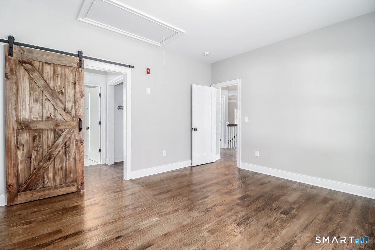53 Pembroke Road Danbury, CT 06811 - Photo 27 of 37 a view of an empty room with wooden floor and a window
