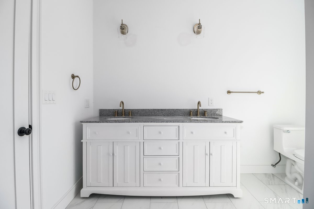 53 Pembroke Road Danbury, CT 06811 - Photo 30 of 37 a bathroom with a granite countertop sink and a toilet