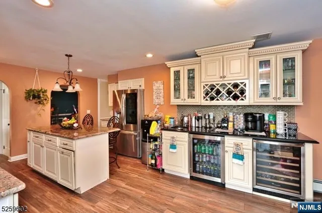 a kitchen with stainless steel appliances kitchen island granite countertop a stove and a refrigerator
