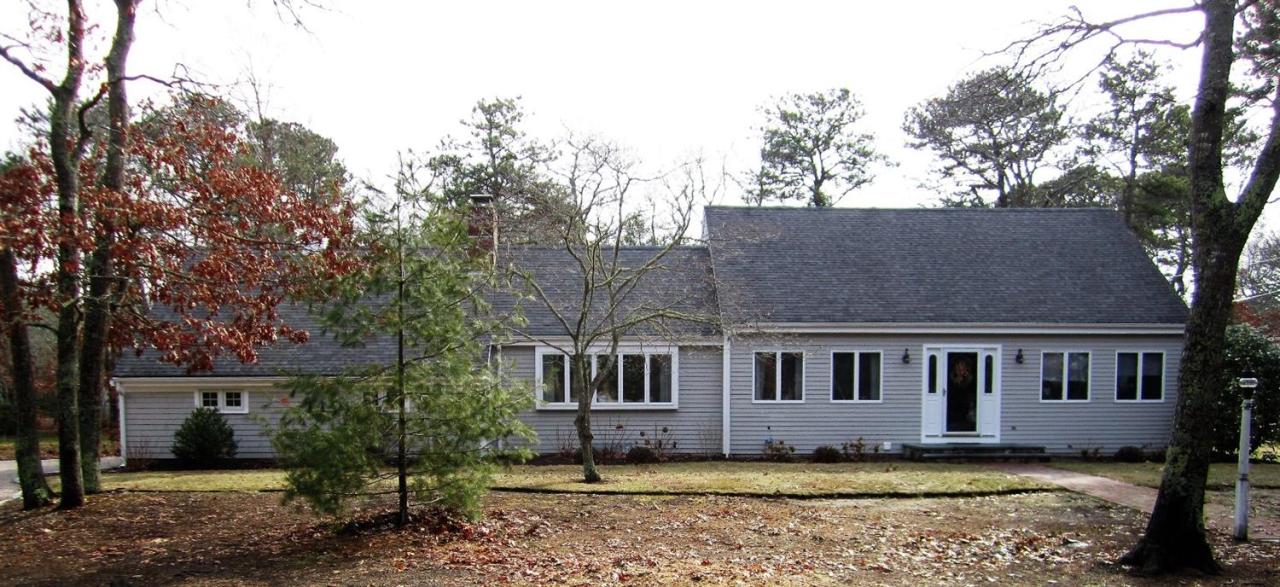11 Cotuit Cove Road Cotuit, MA 02635 - Photo 2 of 35 a front view of a house with a garden