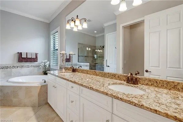 a bathroom with a granite countertop sink and a large mirror