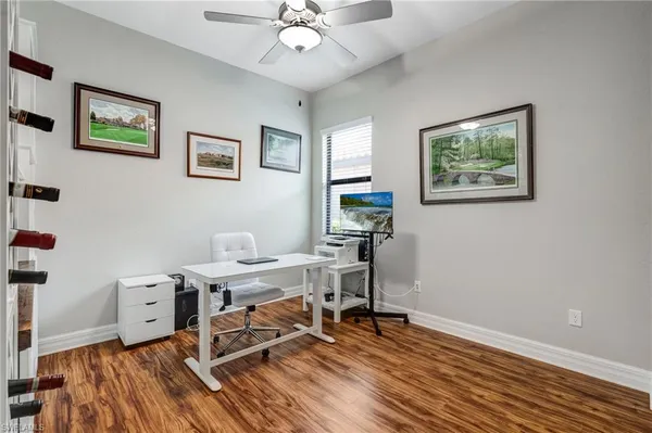 a view of a workspace with wooden floor and a window