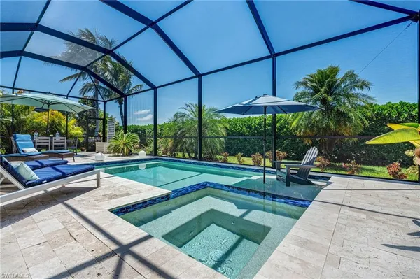 a view of a patio with a table and chairs under an umbrella