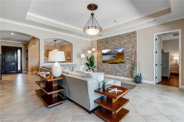 a living room with furniture a flat screen tv and a chandelier