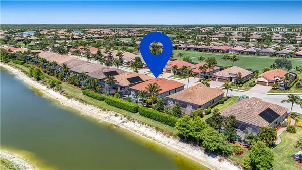 an aerial view of a house with a garden and lake view