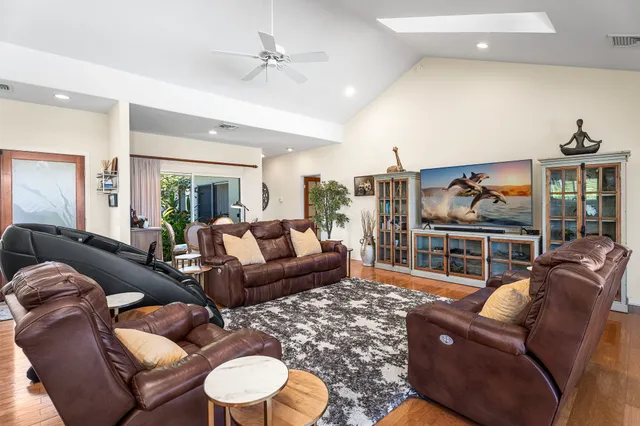 a living room with furniture kitchen view and a large window