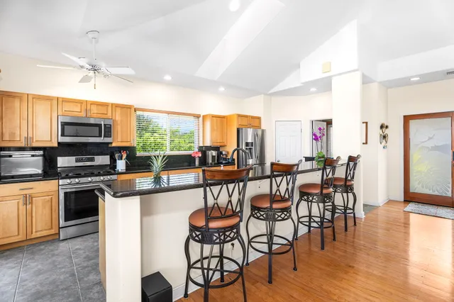 a kitchen with stainless steel appliances granite countertop a stove a sink and a microwave