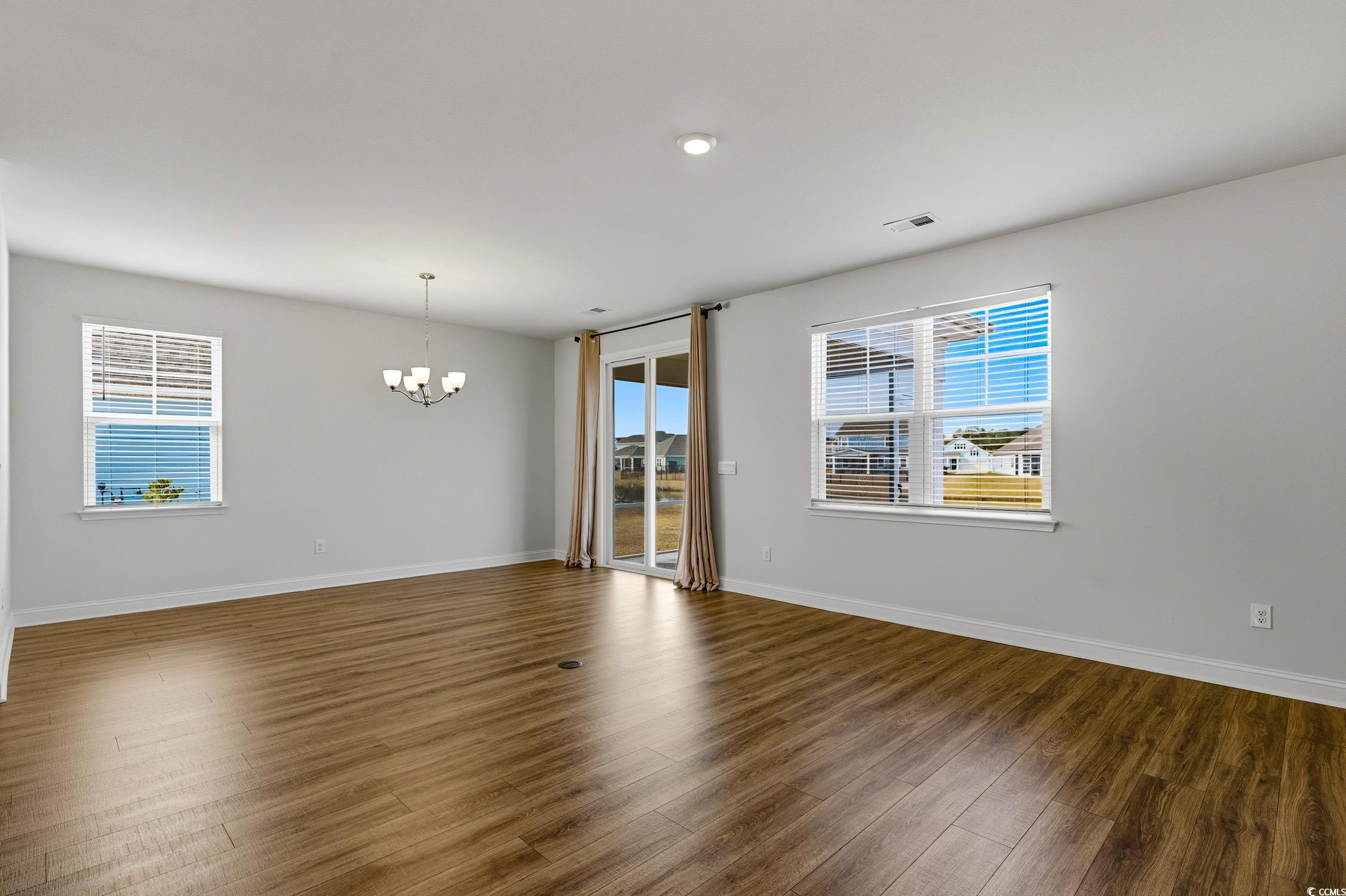 3083 Gillham Loop Myrtle Beach, SC 29588 - Photo 3 of 34 Unfurnished room with wood finished floors and a chandelier