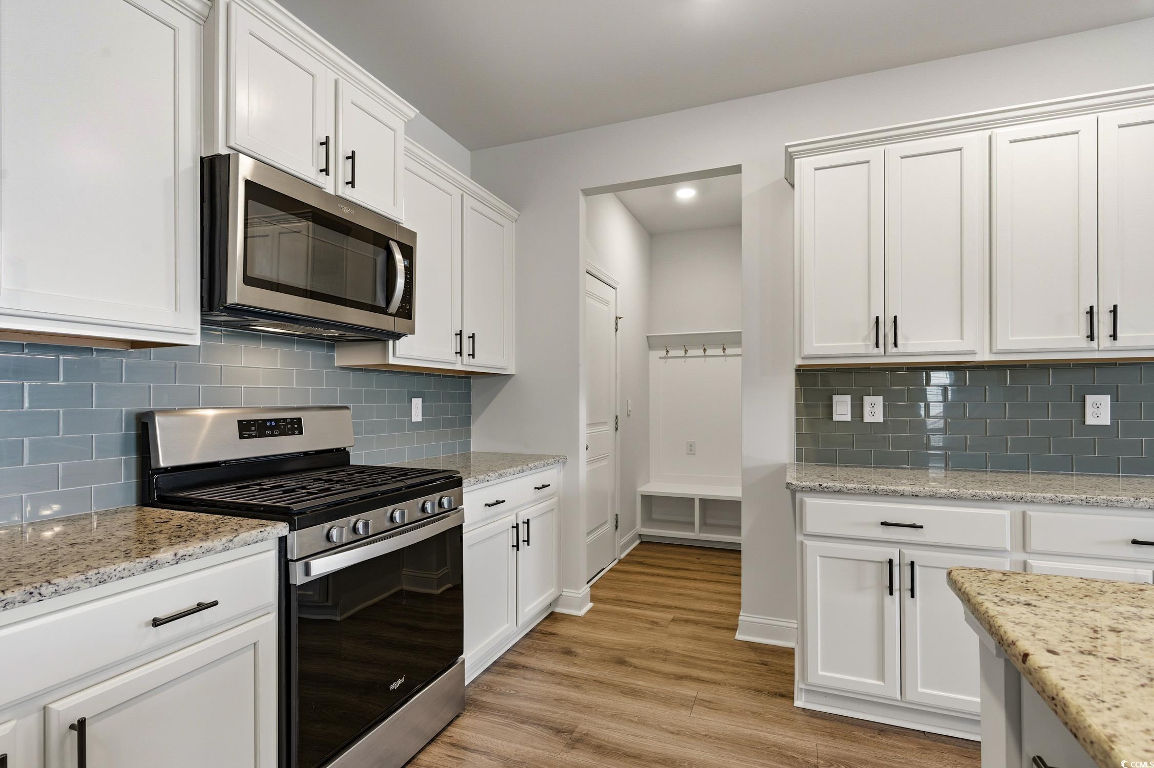 3083 Gillham Loop Myrtle Beach, SC 29588 - Photo 9 of 34 Kitchen with decorative backsplash, dishwasher, pendant lighting, white cabinets, and an island with sink