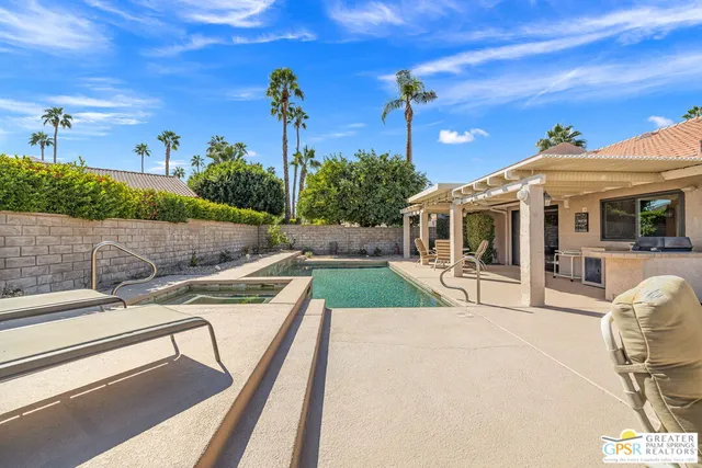 a view of a house with backyard and sitting area