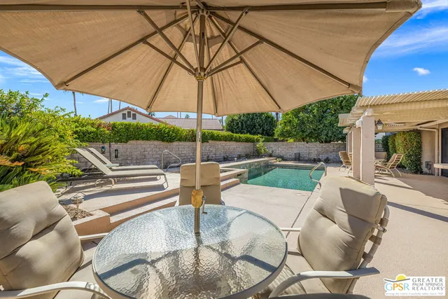 a view of an outdoor sitting area with couch and umbrella