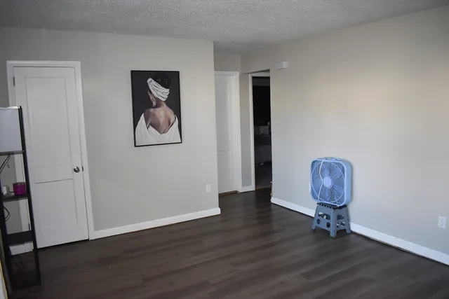 a view of room with hardwood floor and hallway