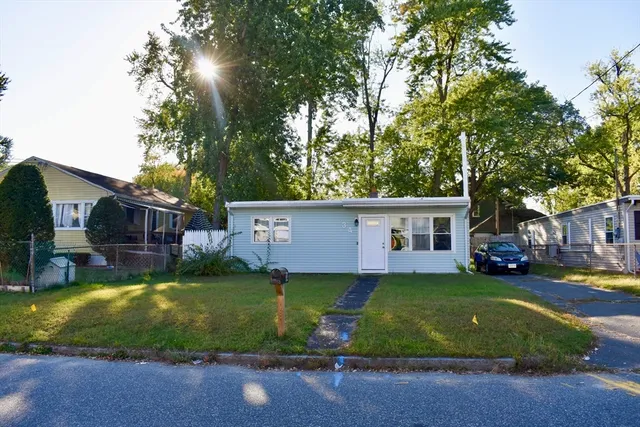 a view of a house with a big yard and large trees