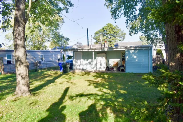 a view of a house with a yard and tree s