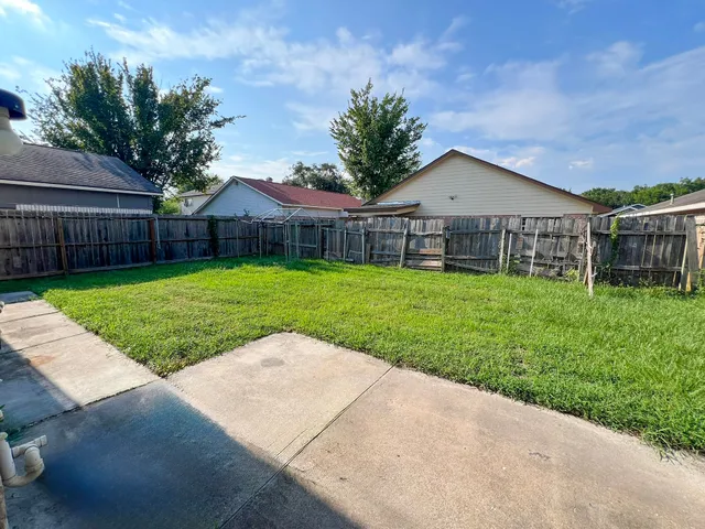 a view of a house with a yard and potted plants