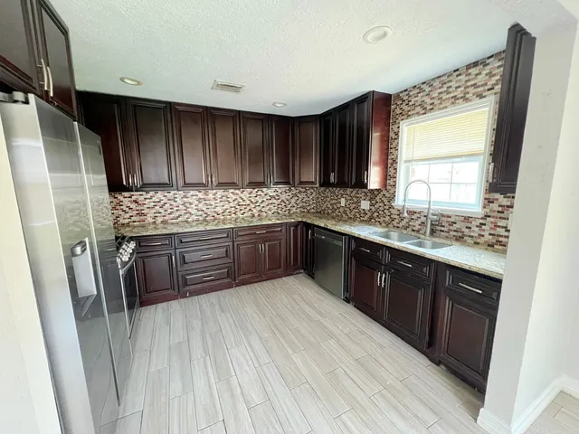 a kitchen with stainless steel appliances granite countertop wooden cabinets a sink and dishwasher