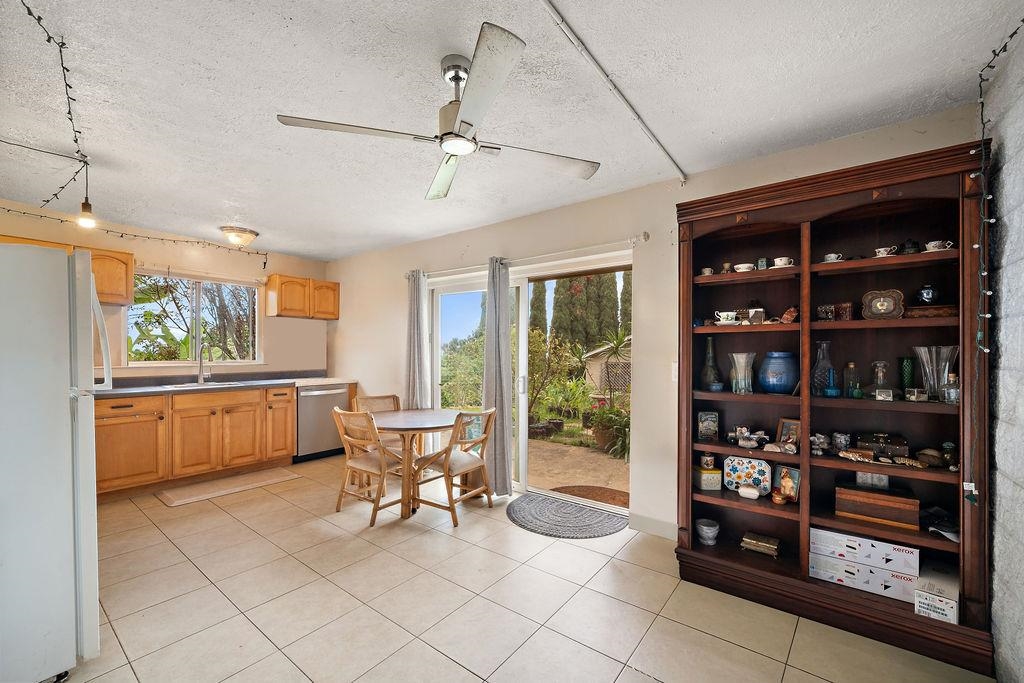 12 Upper Kimo Drive Kula, HI 96790 - Photo 21 of 30 a dining room with stainless steel appliances kitchen island granite countertop a refrigerator a stove a dining table and chairs with the view of kitchen