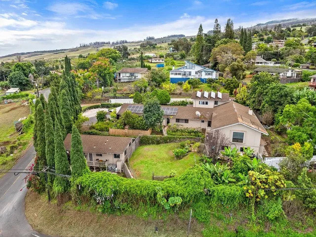 an aerial view of residential houses with outdoor space and street view
