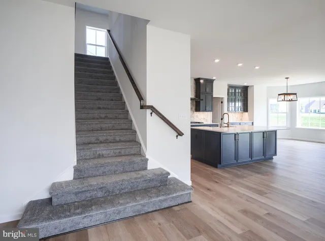 a large kitchen with stainless steel appliances a large counter top a sink and a window