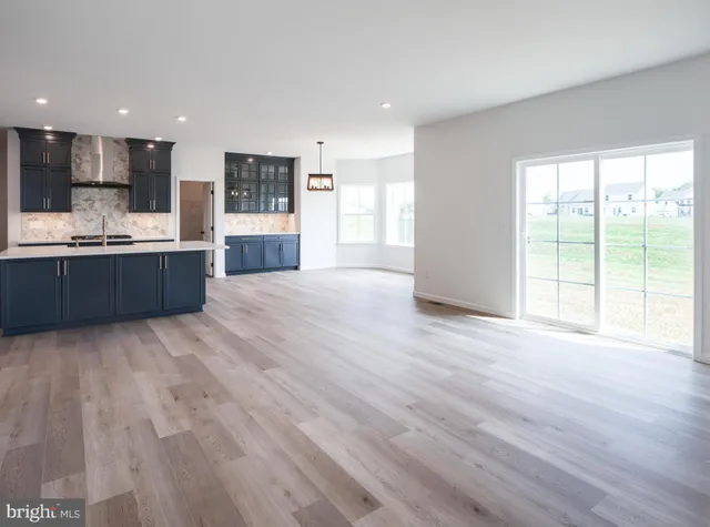 a large kitchen with stainless steel appliances kitchen island granite countertop a large counter top and wooden floors