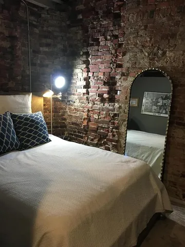 a living room with stainless steel appliances a refrigerator a stove a microwave and furniture