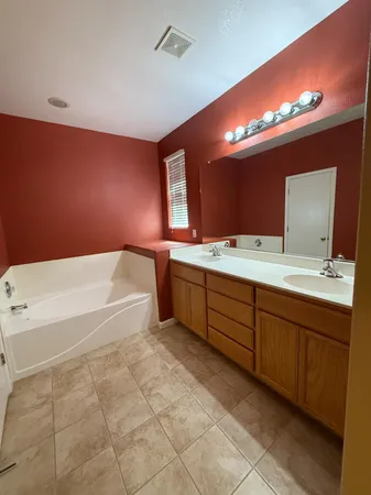 a backyard of a house with table and chairs and a large tree